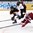 ZUG, SWITZERLAND - APRIL 23: Latvia's Emils Ezitis #21 and Germany's Tobias Fohrler #5 chasing down a loose puck during relegation round action at the 2015 IIHF Ice Hockey U18 World Championship. (Photo by Francois Laplante/HHOF-IIHF Images)